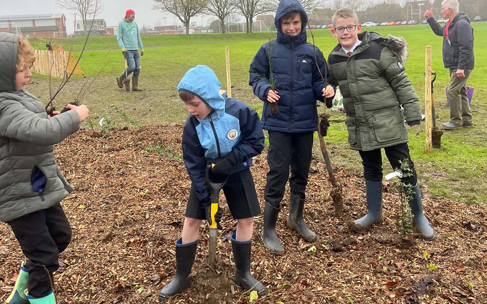 Robert Bloomfield Academy Tiny Forest school boy planting a shrub